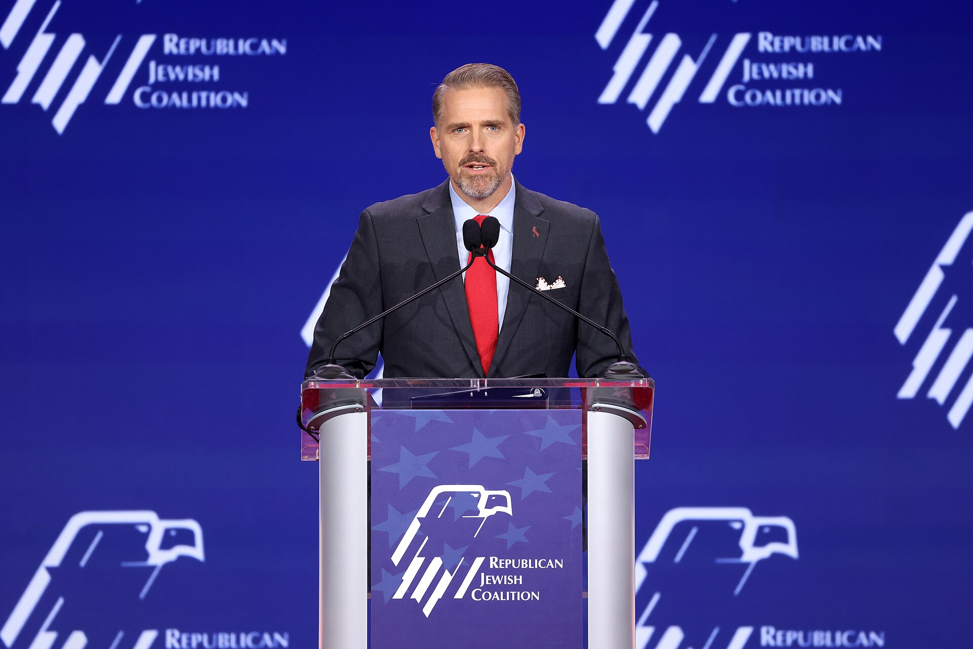 Scott Jennings speaking at a podium at the Republican Jewish Coalition's 2026 Annual Leadership Summit in Las Vegas