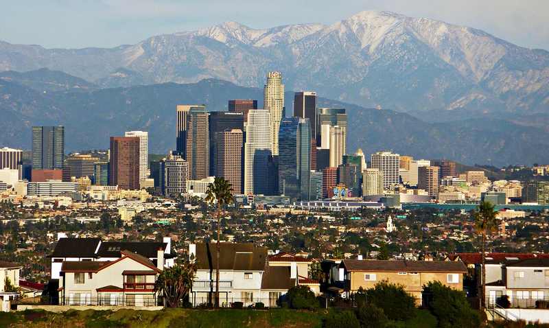 Downtown Los Angeles skyline beneath the San Gabriel Mountains — one of the two California cities named in Trump's 'let them hit' comments