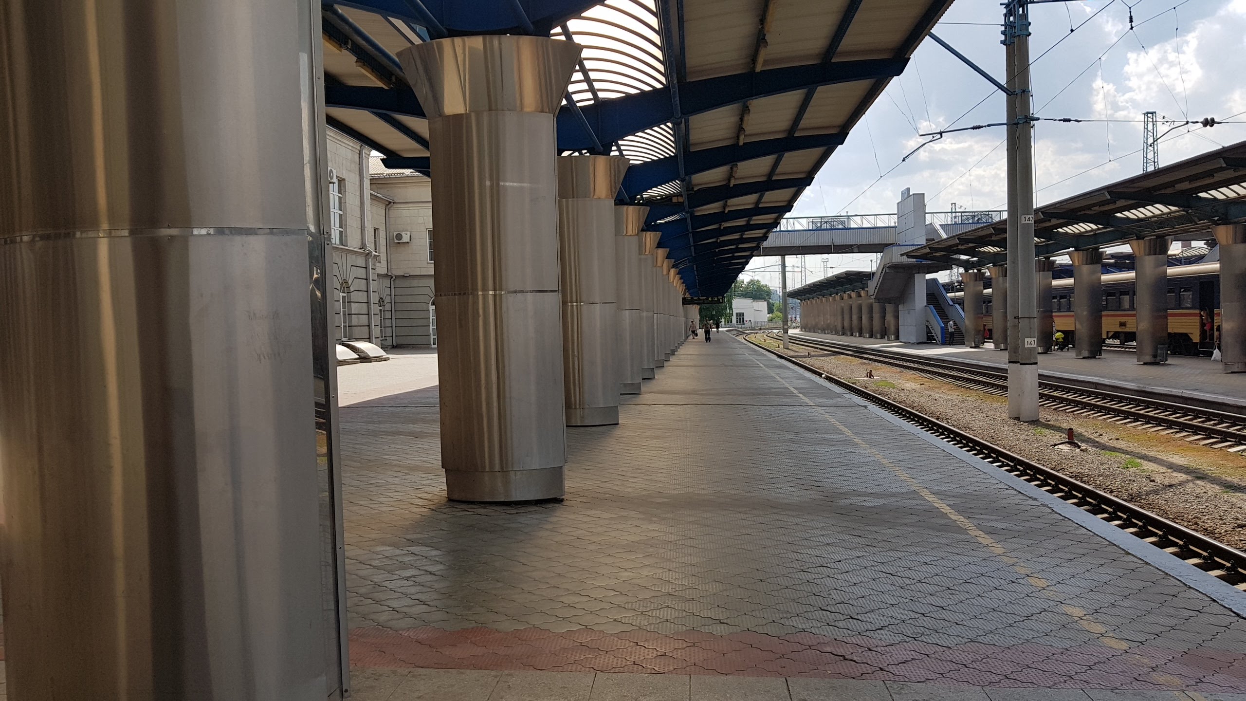 A platform at Dnipro central railway station with a Ukrainian Railways passenger train standing at the far platform — a file photograph of the station's platforms