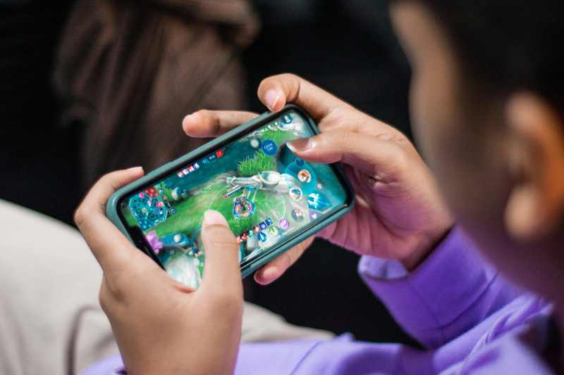 Young player using a smartphone game as EU authorities examine virtual currency transparency and protections for minors