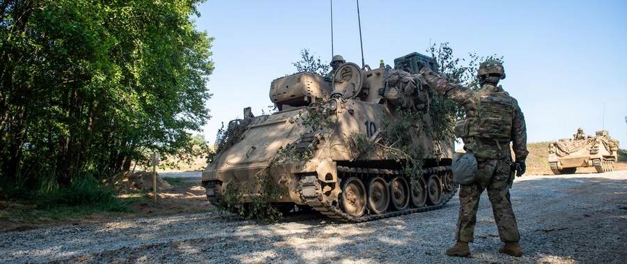U.S. Army armored vehicles and a soldier during an emergency deployment readiness exercise in Poland