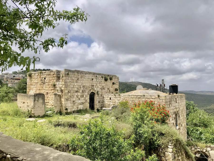 Stone house and green hillside in the Palestinian village of Yasuf in the occupied West Bank