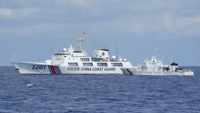 Chinese and Philippine coast guard vessels sailing in close proximity in the South China Sea