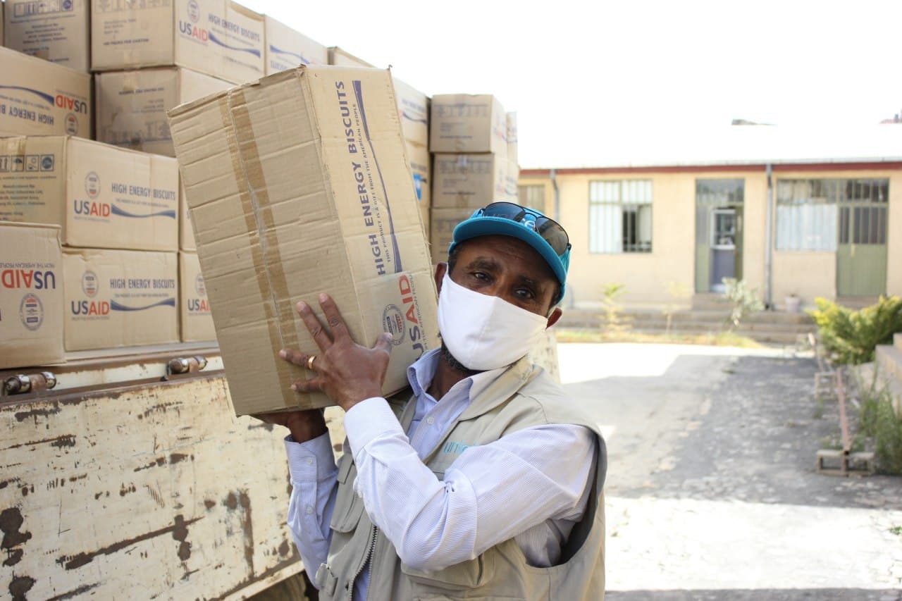 A USAID aid worker unloads high-energy biscuits for displaced people in Tigray, Ethiopia — file photo; Amhara's camps face worsening food and medicine shortages as aid groups scale back