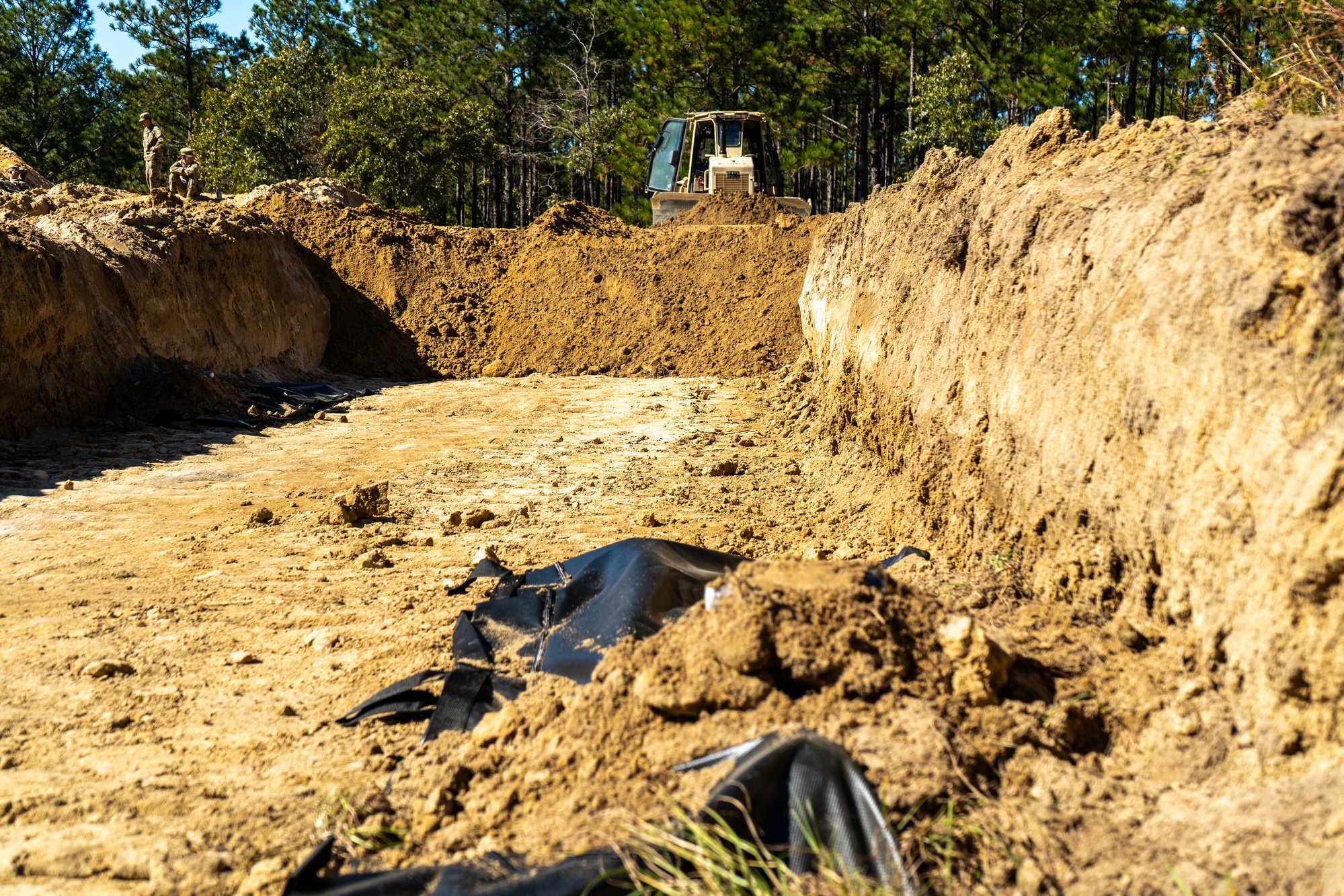 Army mass graves training — a U.S. Army D6 bulldozer backfills a simulated temporary interment trench during Operation Dragon Covenant at Fort Bragg