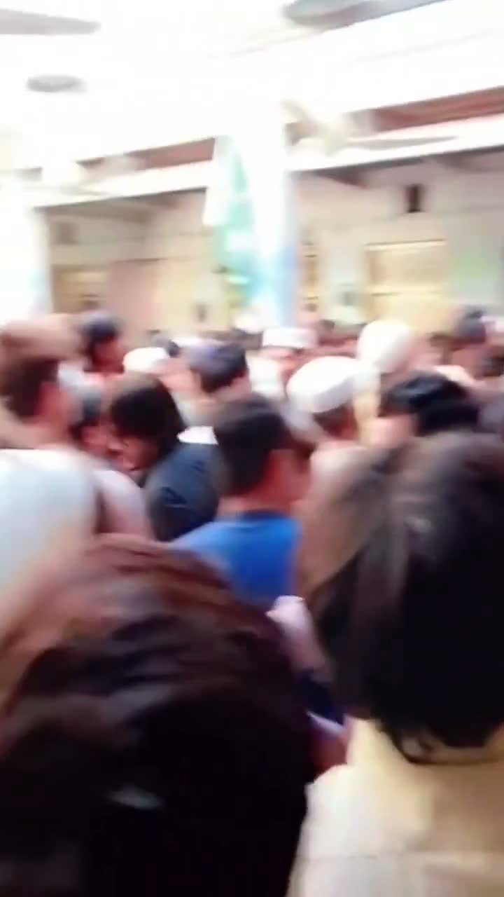 Rescuers, parents and residents crowd a corridor inside the Al-Khair Education Centre in Peshawar minutes after the school roof collapse — still from video of the scene