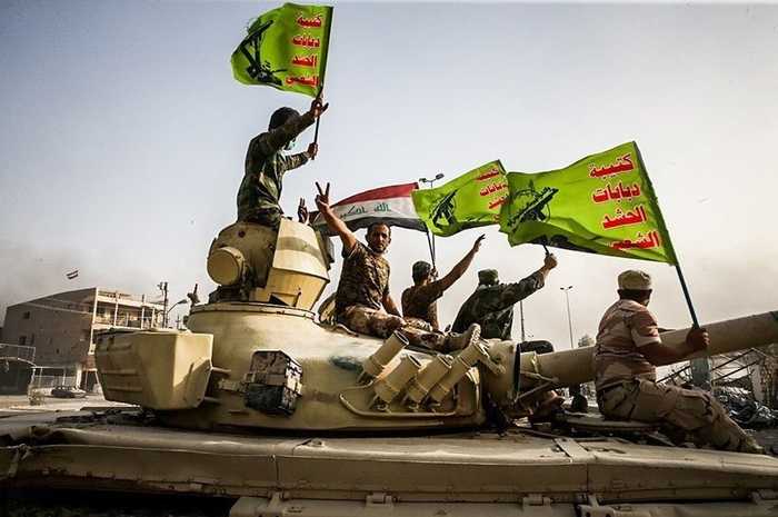 Popular Mobilization Forces fighters raise Iraqi and PMF flags — Iran-backed militias in Iraq face a disarmament deadline