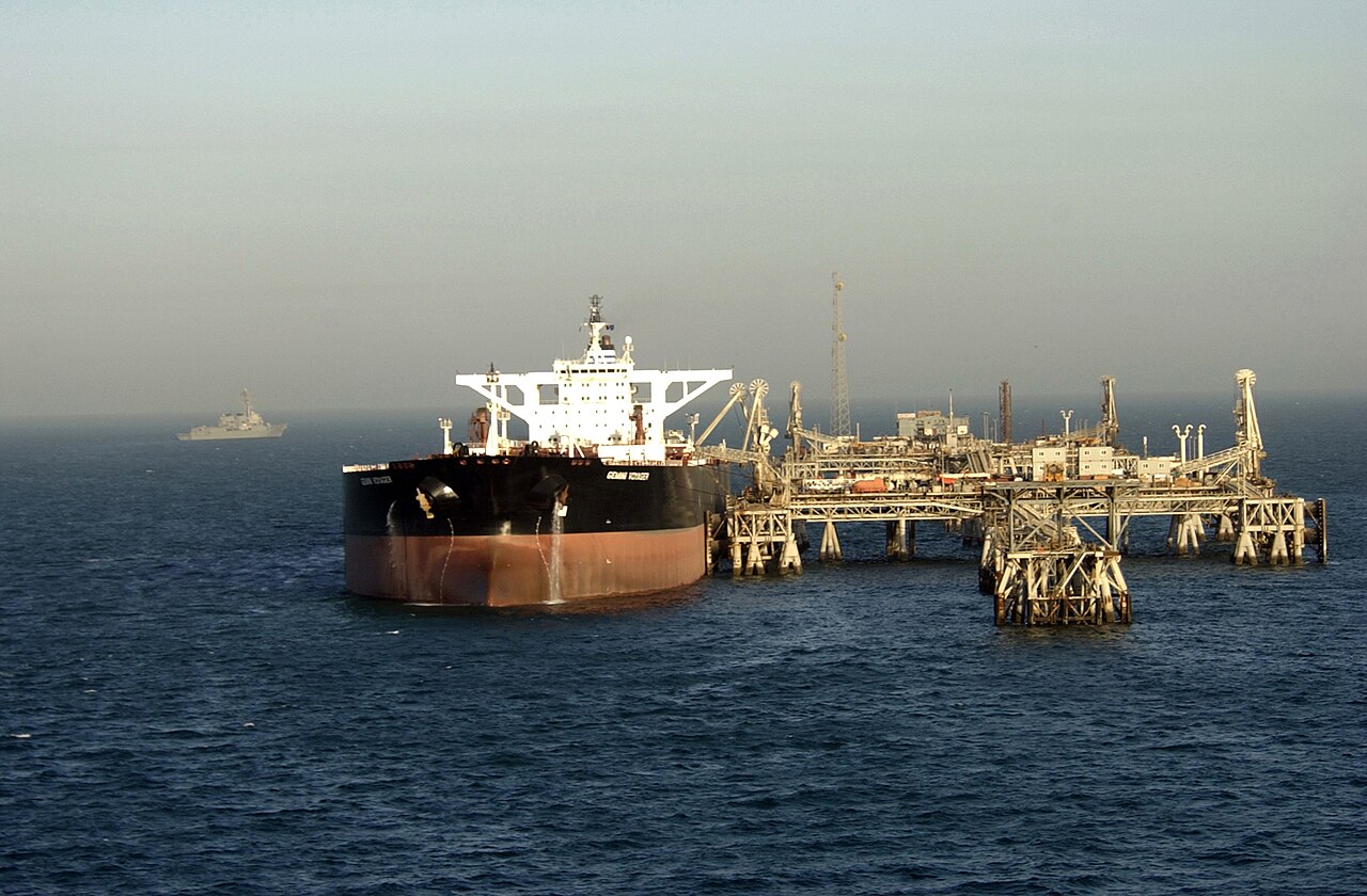 A super tanker takes on crude oil at the Al Basrah Oil Terminal while the destroyer USS Preble patrols nearby