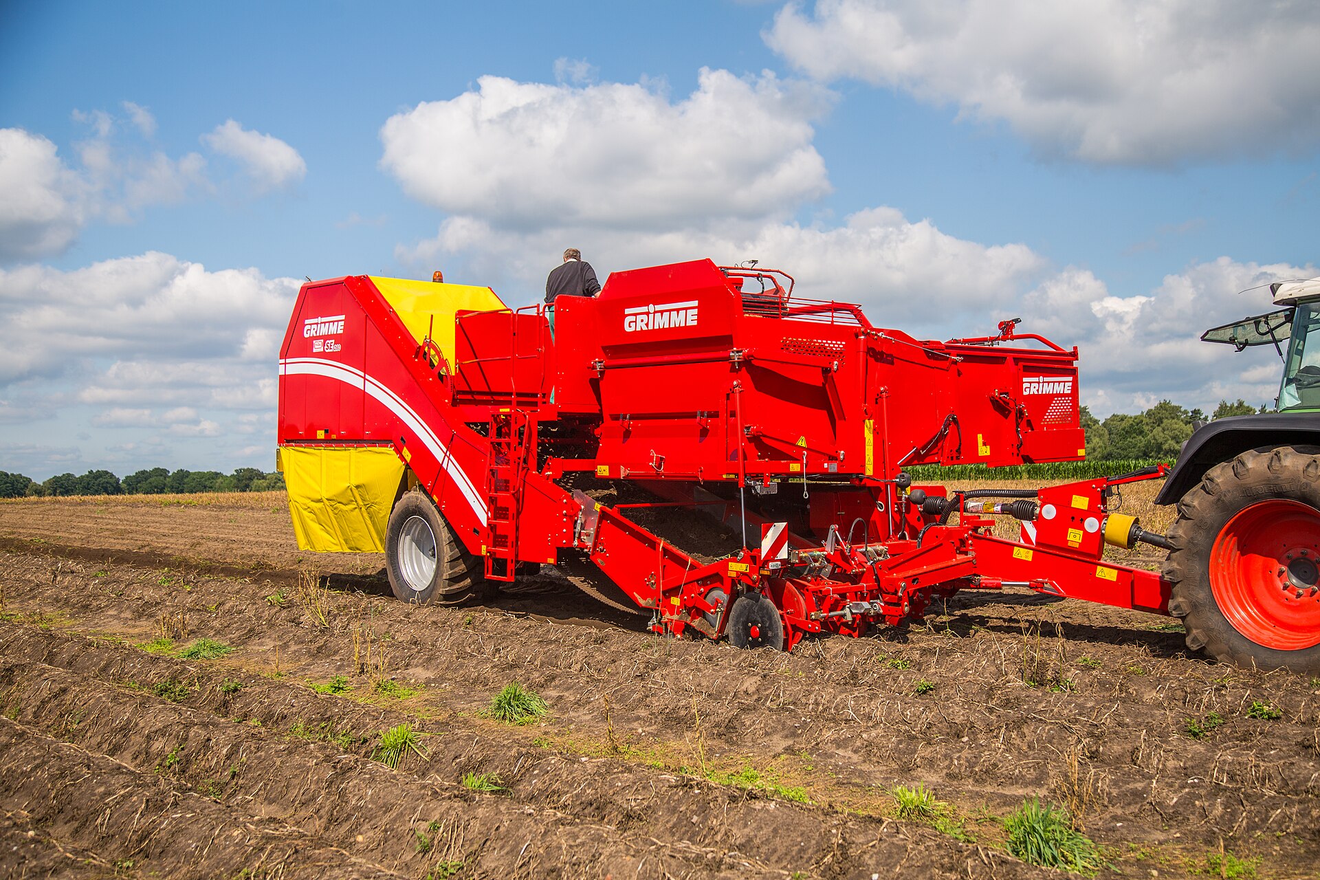 A potato harvester working a field — potatoes are among the nine exempted categories in the Canada tariff change