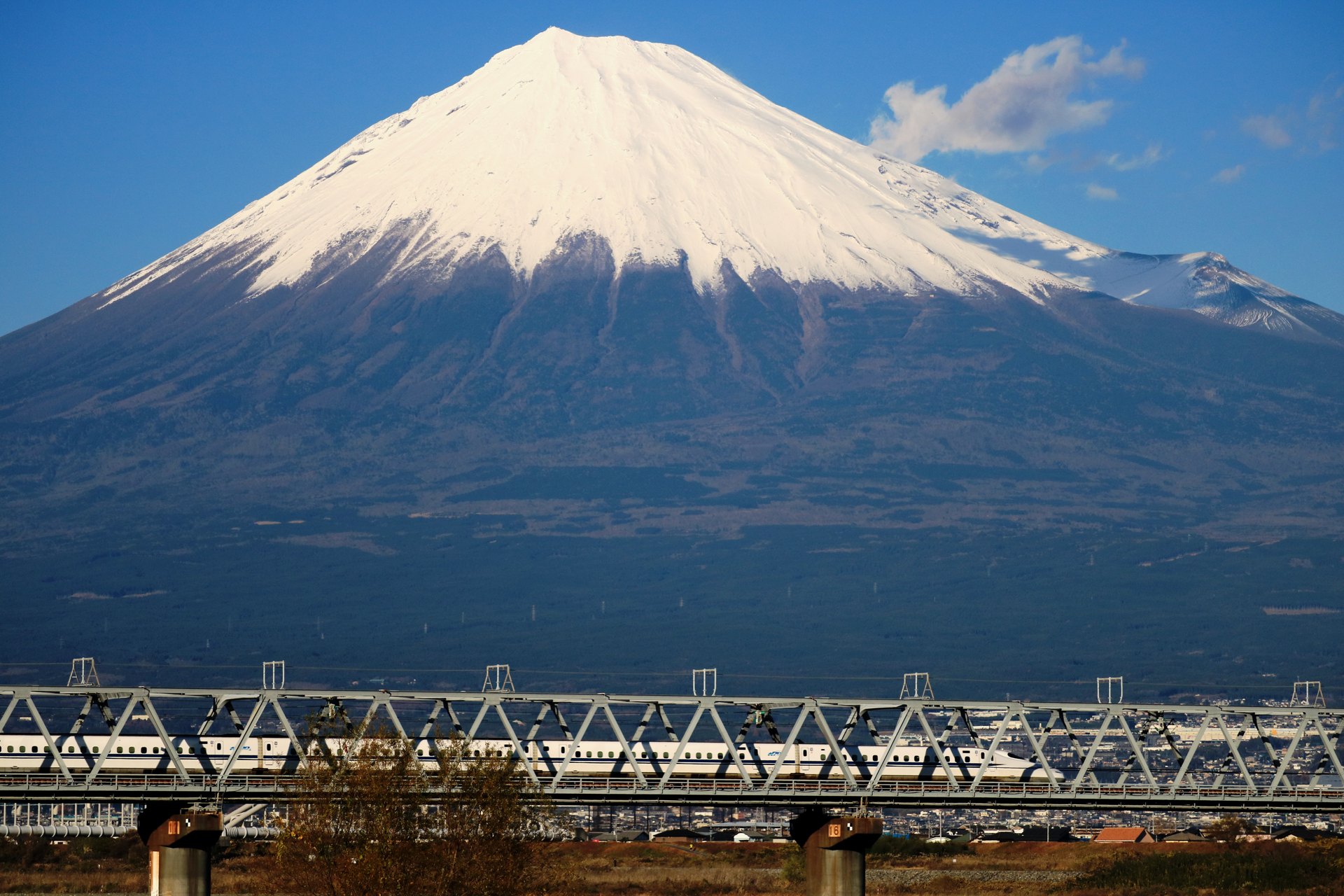 A Tokaido Shinkansen train crossing a bridge beneath Mount Fuji — file photograph