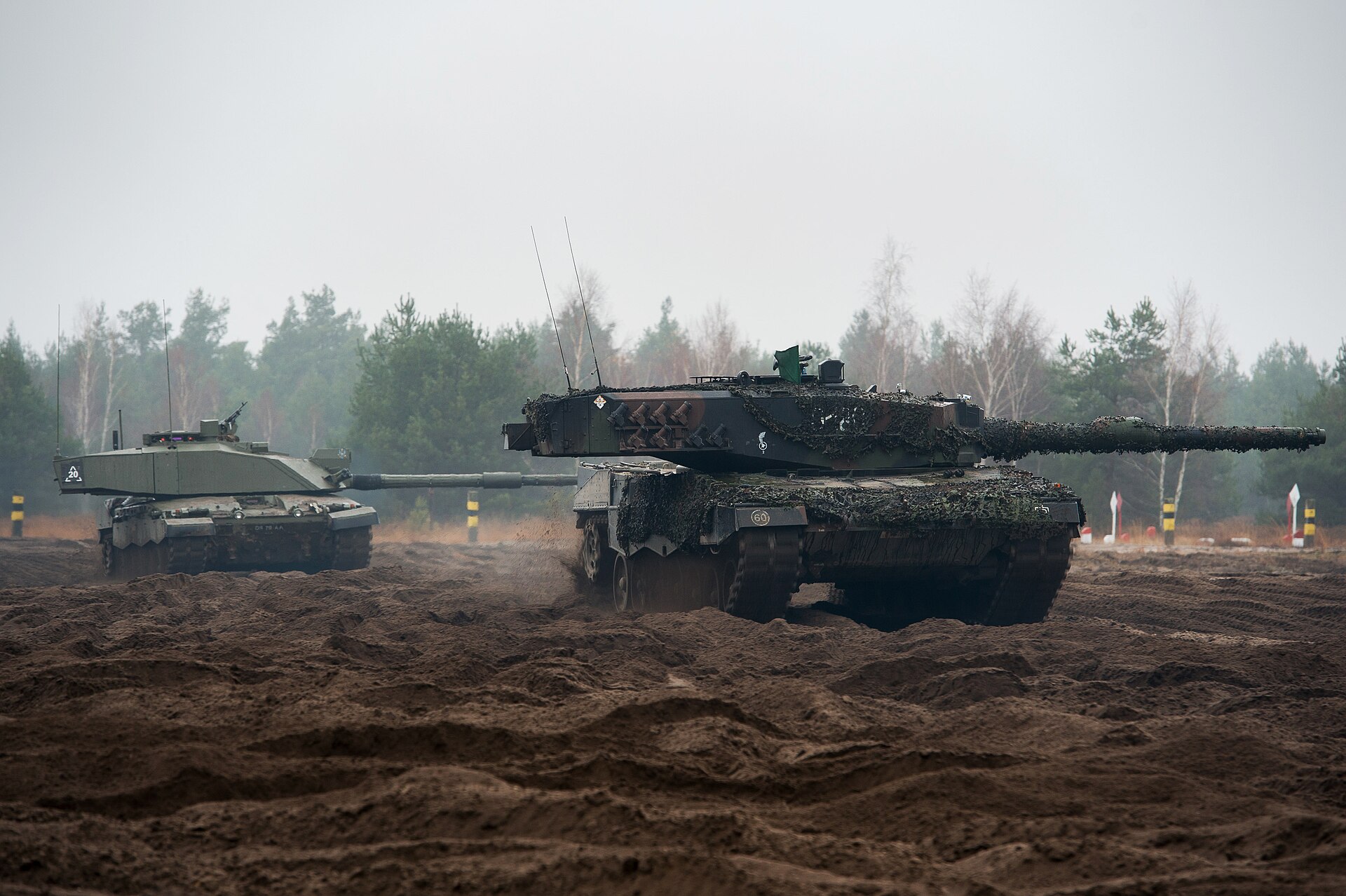 A British Challenger 2 tank alongside a Polish Leopard 2 on exercise in Poland — British and Polish armour training together, a partnership the UK Poland defence plan signed in Warsaw now extends for three years