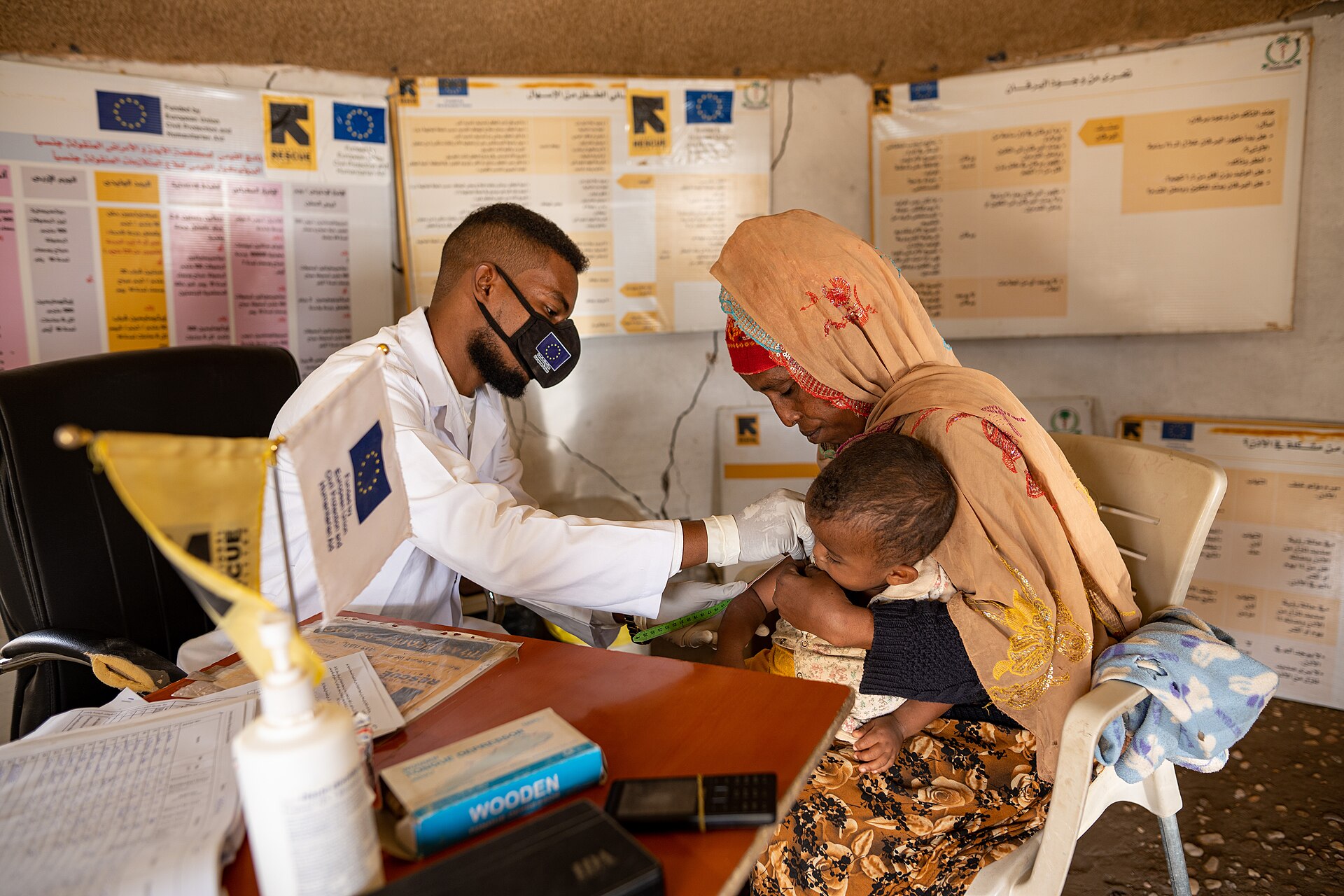 Sudan RSF hospital attacks — an International Rescue Committee doctor measures a child's arm during a malnutrition screening at a clinic in Gedaref, Sudan, as the child's mother holds them — file photo