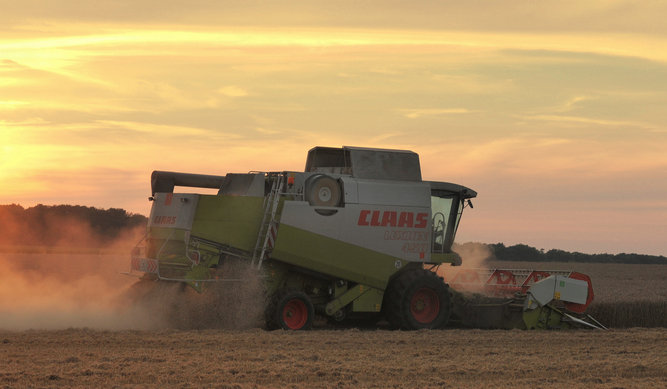 A combine harvester threshing wheat at sunset in Lower Saxony, Germany, as world food prices hit a four-year high on Black Sea trade disruptions