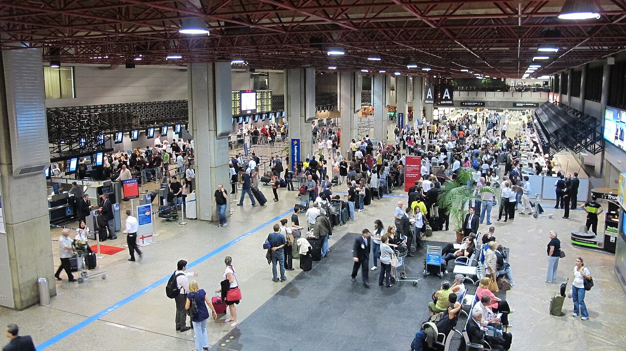 Crowds of travelers queueing at airport check-in counters