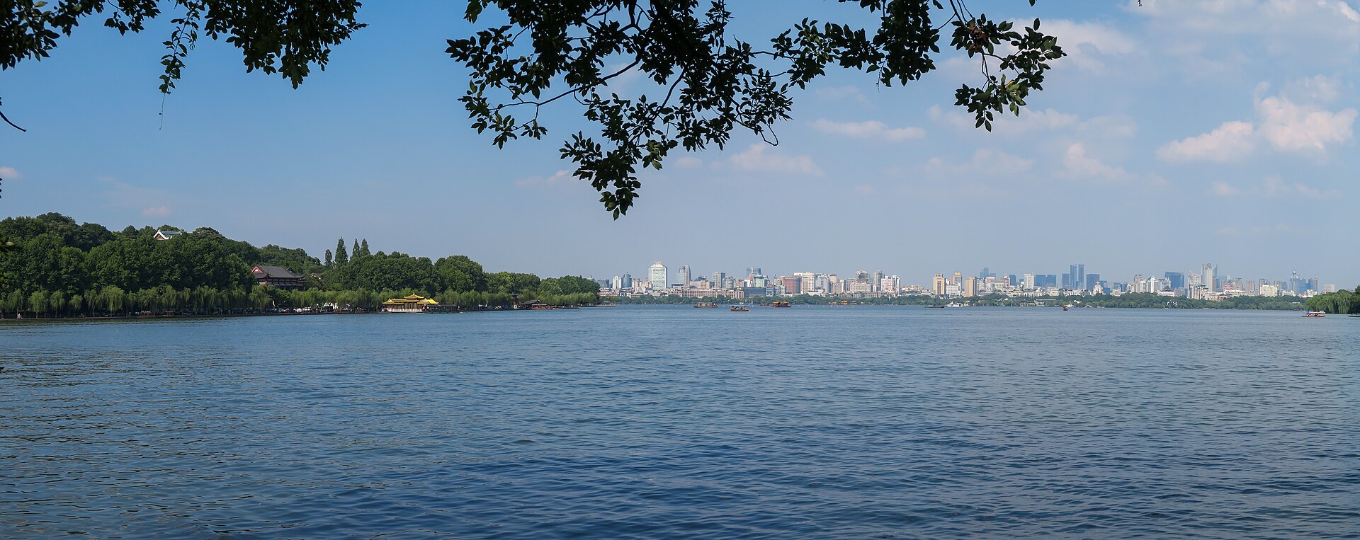 Hangzhou skyline across West Lake — DeepSeek's home city, where the lab was founded in 2023 by Liang Wenfeng out of the High-Flyer quant fund