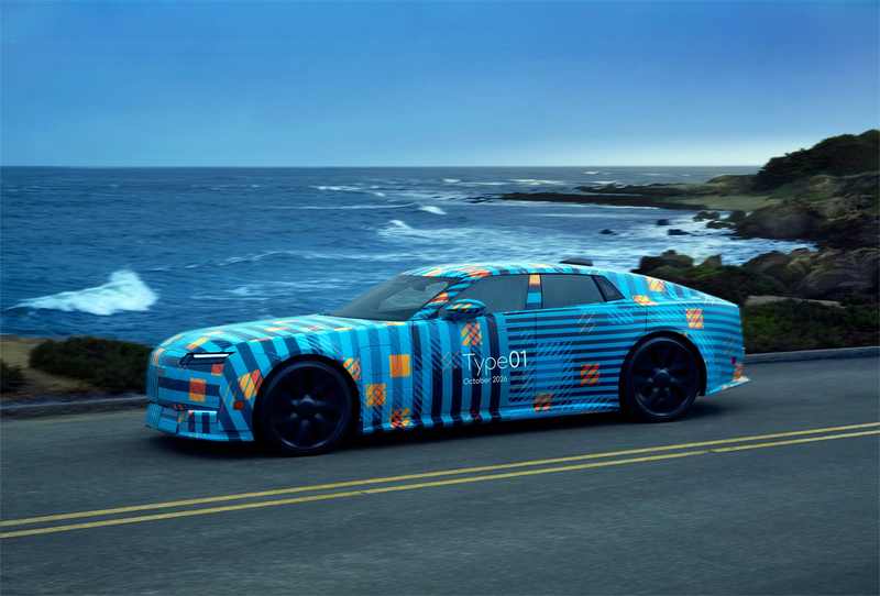 Camouflaged Jaguar Type 01 electric car prototype driving beside the ocean