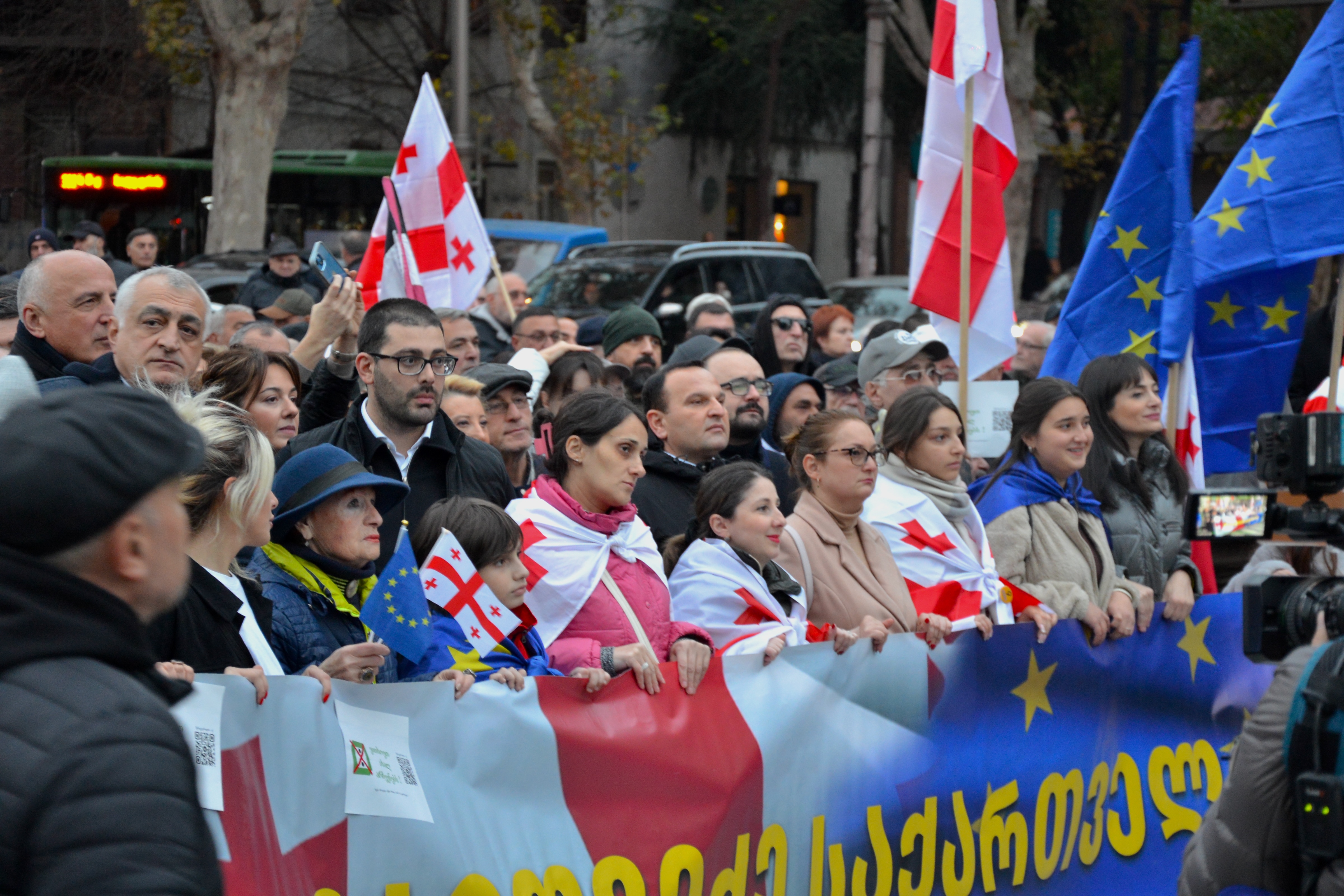 Georgia opposition parties ban hearing — Georgians carrying national and EU flags march toward Rustaveli Avenue in Tbilisi during the November 2024 election protests