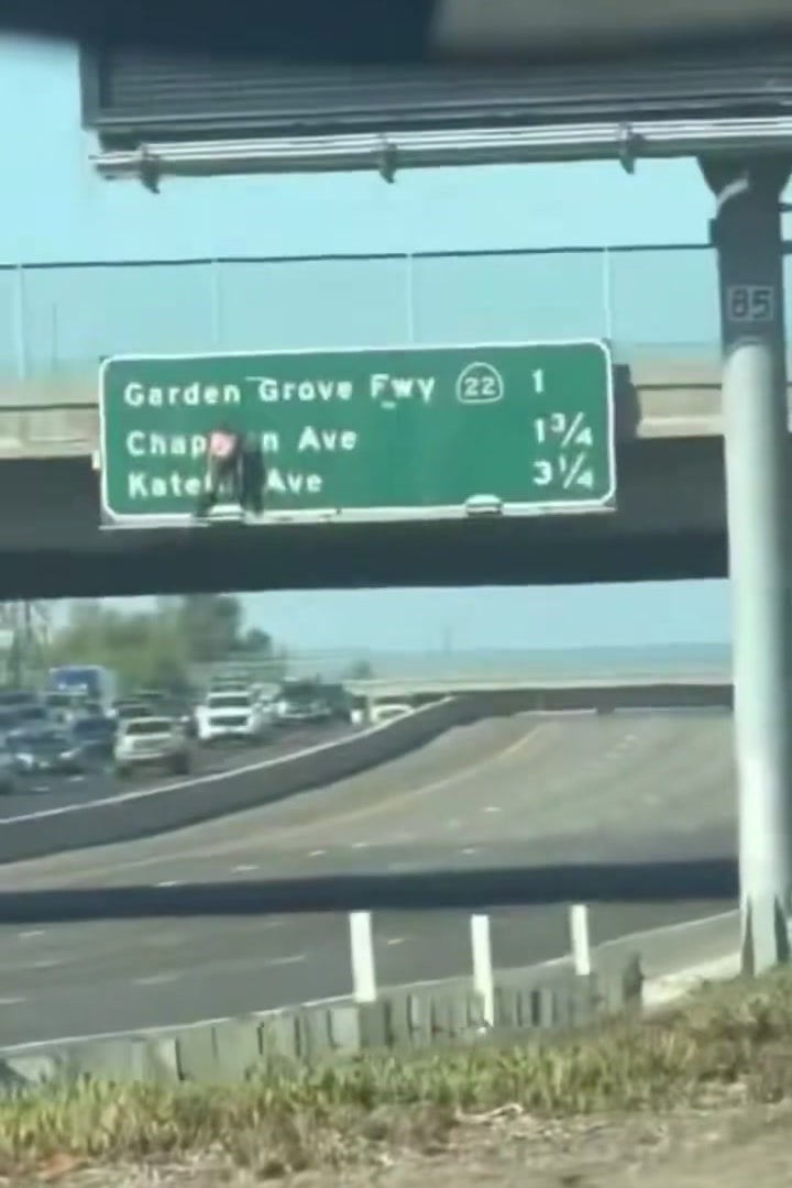 Wide view of the overhead freeway sign above the 55 Freeway in Santa Ana during the shutdown, with traffic stopped below