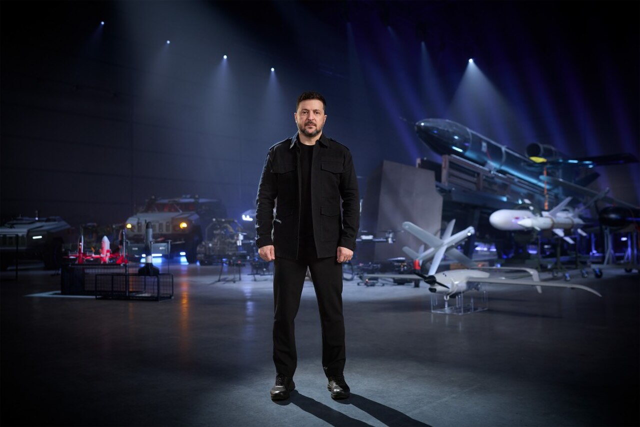 Ukrainian President Volodymyr Zelenskyy standing before Ukrainian long-range strike weapons and drones