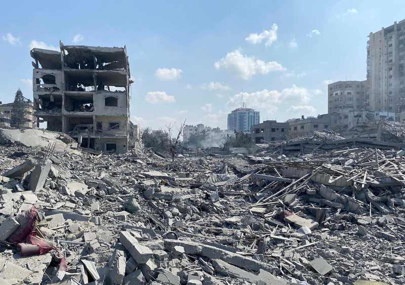 Palestinians inspect Gaza City damage in a file photo accompanying the report that a Hamas commander was killed in Gaza