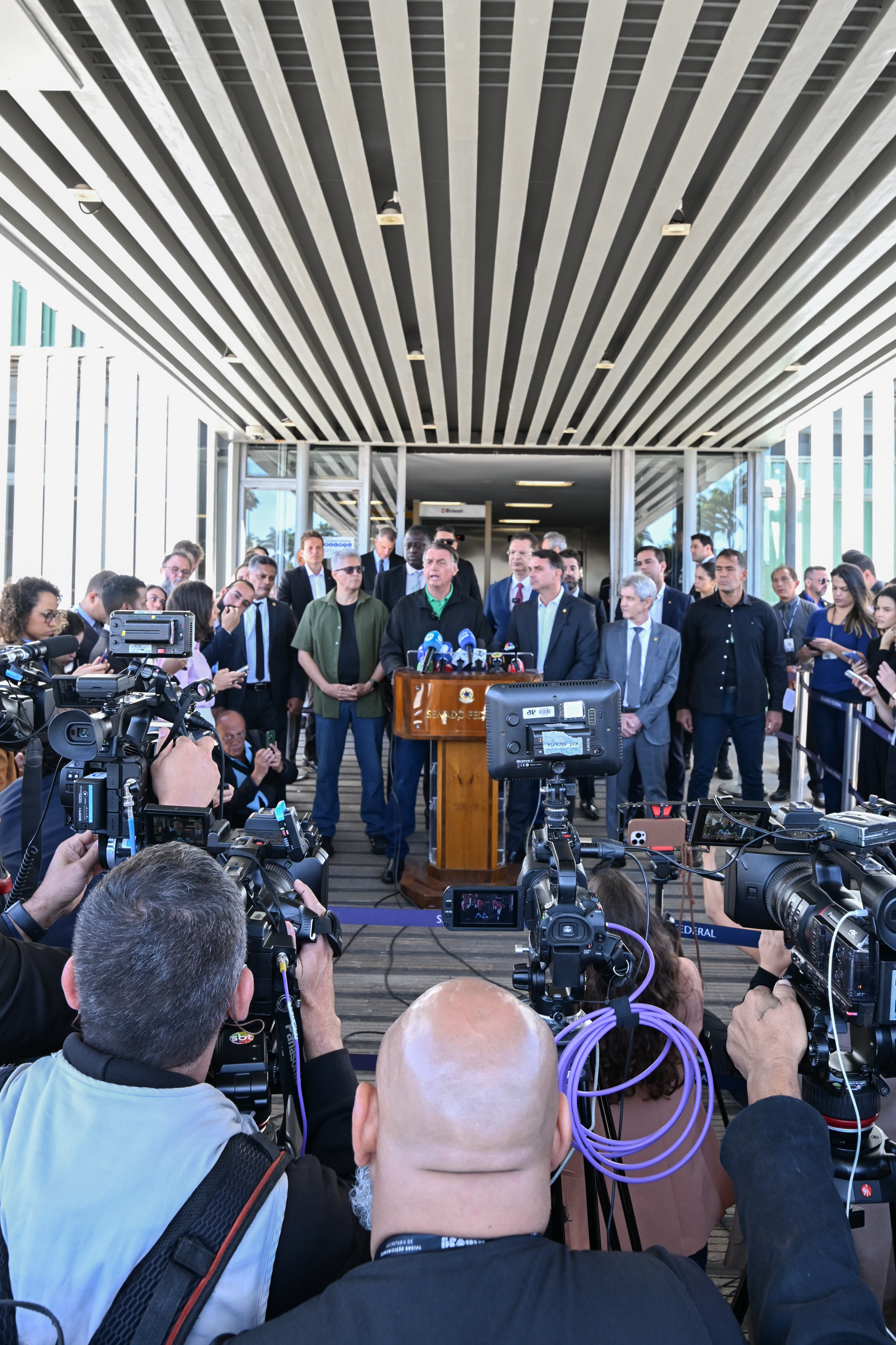 Former president Jair Bolsonaro at a July 2025 Senate press conference with son Flávio Bolsonaro — Brazil election 2026 pardon promise at stake