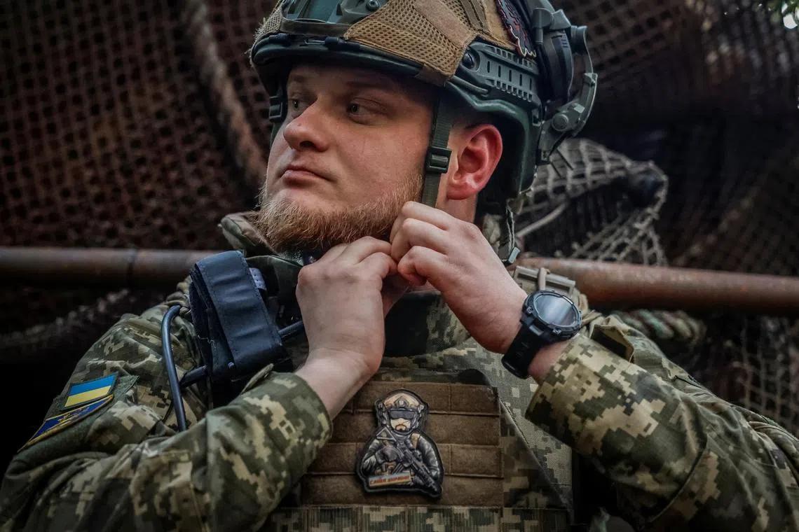 A Ukrainian soldier fastening his helmet at a front-line position in Ukraine, one of the troops who would hold the line of contact under a freeze of the front lines