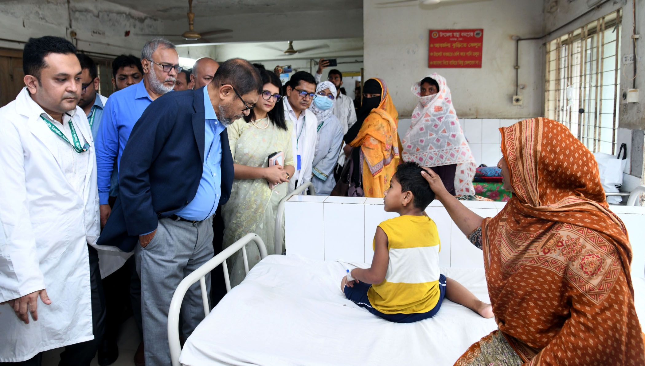 Health officials visiting a young patient in a Dhaka health complex during the April 2026 emergency response to the Bangladesh measles outbreak