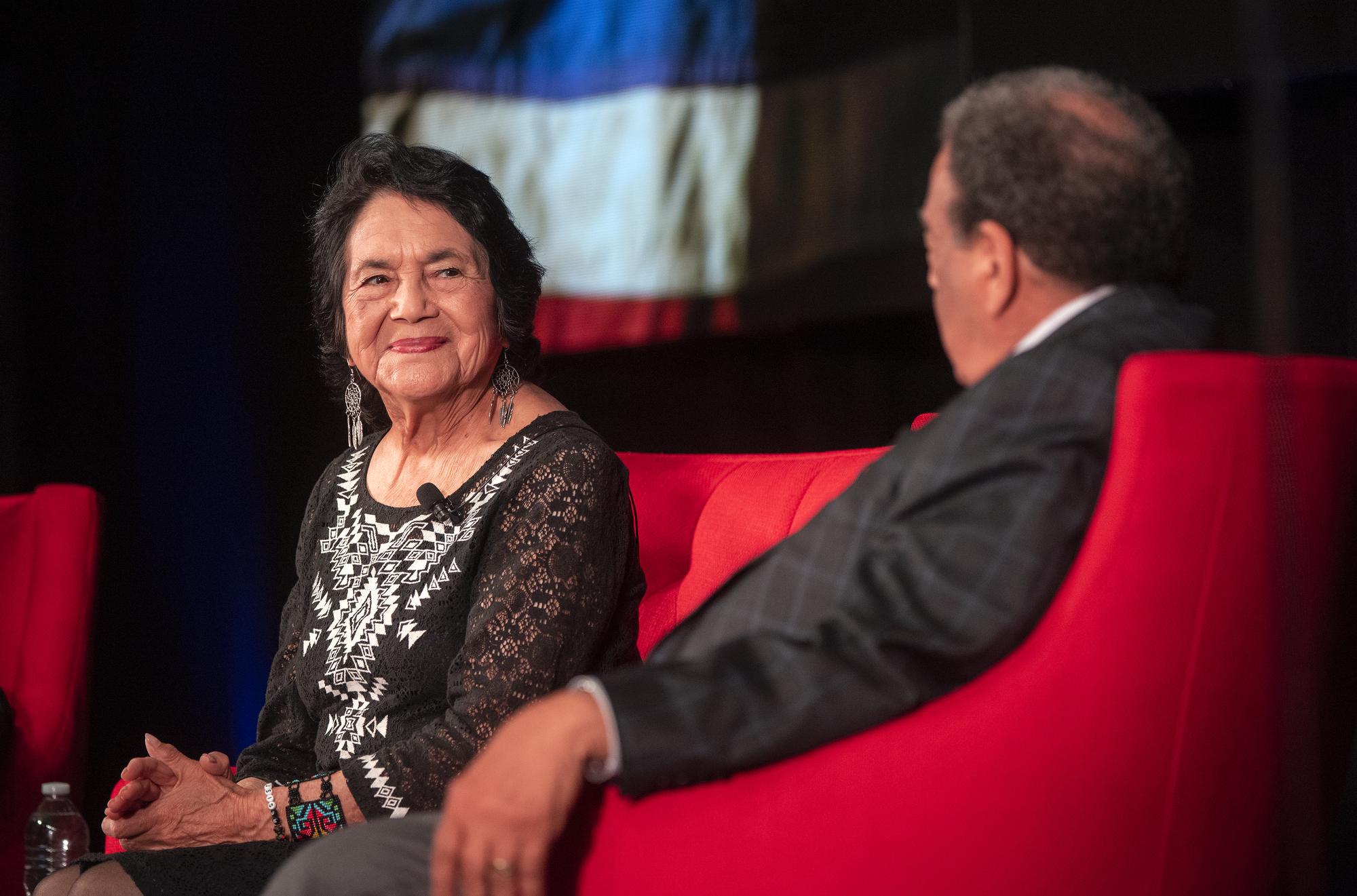 Dolores Huerta seated on stage at the LBJ Presidential Library in 2019 during a discussion with Andrew Young