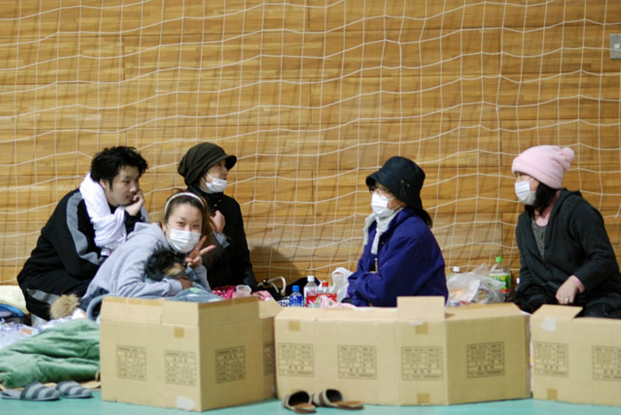 Evacuees from the 2011 Fukushima disaster resting with cardboard boxes in an evacuation shelter, the conditions the new Japan disaster agency aims to replace
