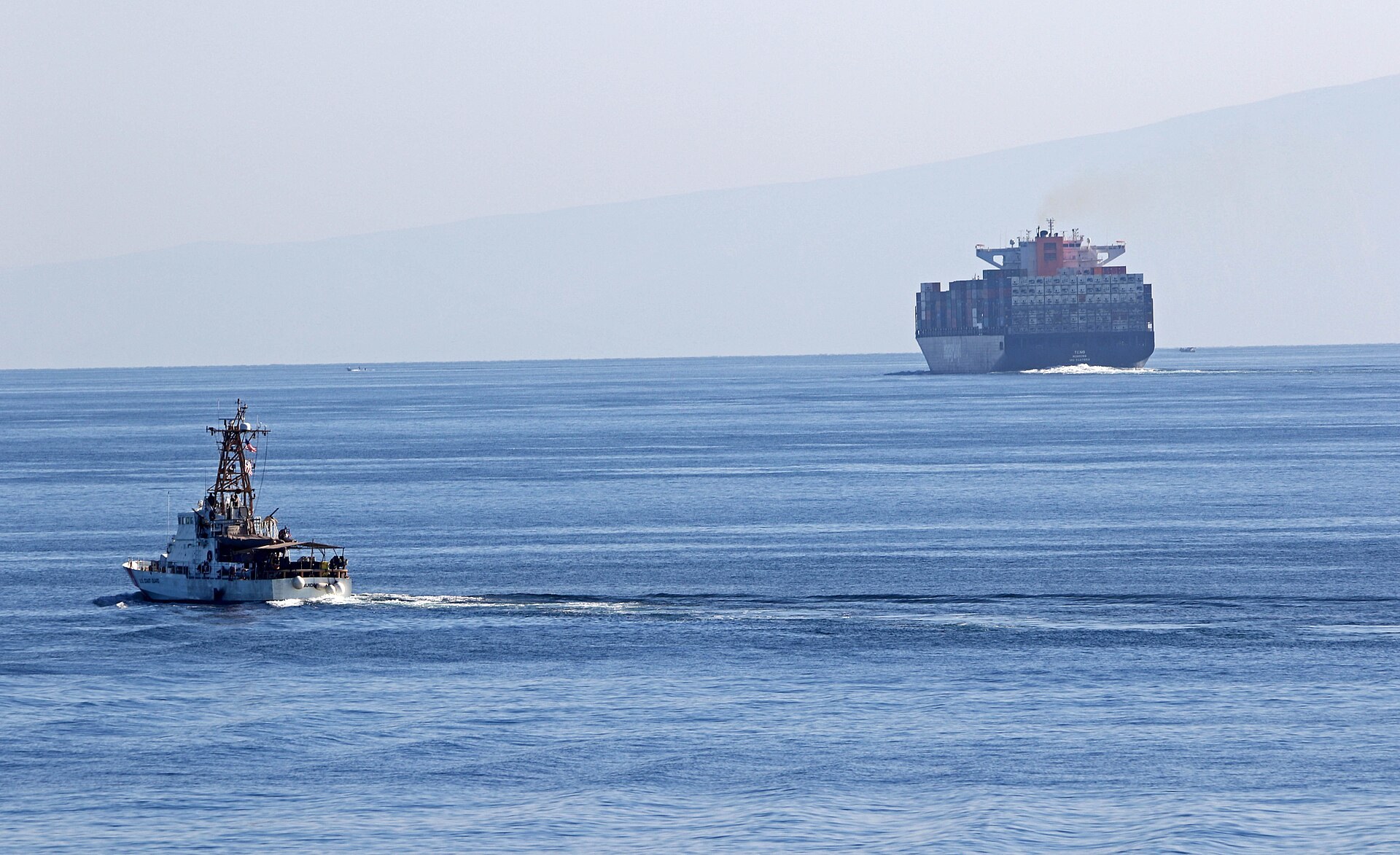 The US Coast Guard cutter USCGC Aquidneck transiting the Strait of Hormuz alongside a container ship, the waterway at the centre of the Strait of Hormuz reopening deal