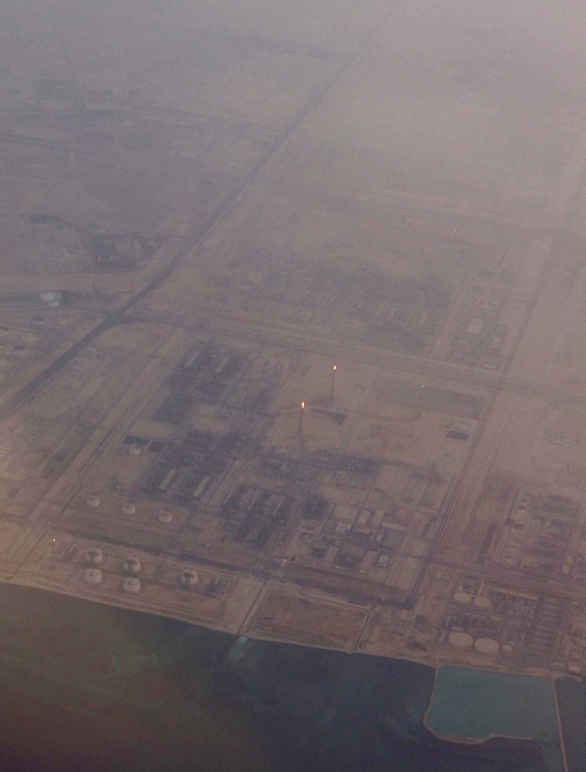 An aerial view of the Ras Laffan industrial complex on Qatar's north-east coast, its LNG trains, storage tanks and gas flares beside the Gulf