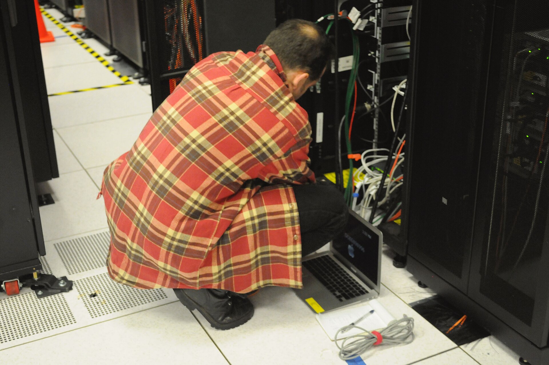 eMudhra certificate keys compromised — a technician working at an open server rack with a laptop