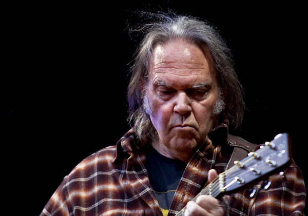 Neil Young sues Trump — the singer performing live with an acoustic guitar in a file photo