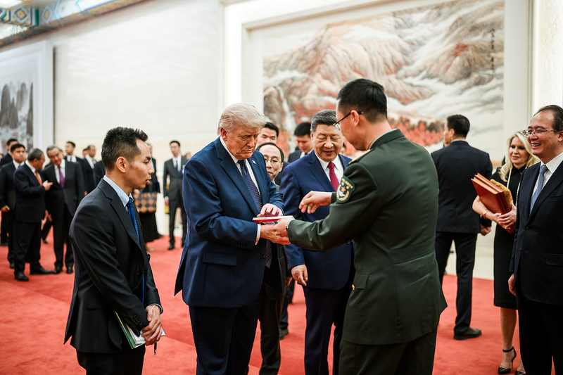 President Donald Trump speaking with guests in Beijing with China's Xi Jinping behind him, as Trump says China is not helping Iran