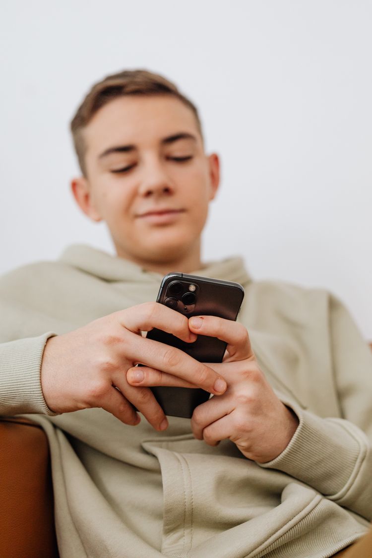 A young person using a smartphone — Character.AI's companion-chatbot app drew 20 million monthly users at its peak and a series of teen-safety lawsuits that the bankruptcy filing cites, file photo