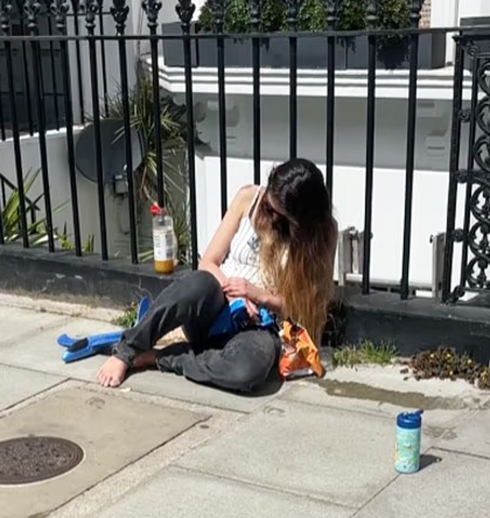 Mahrah Al Nahyan slumped barefoot against railings in a West London street in June 2026, in a still released by prosecutors