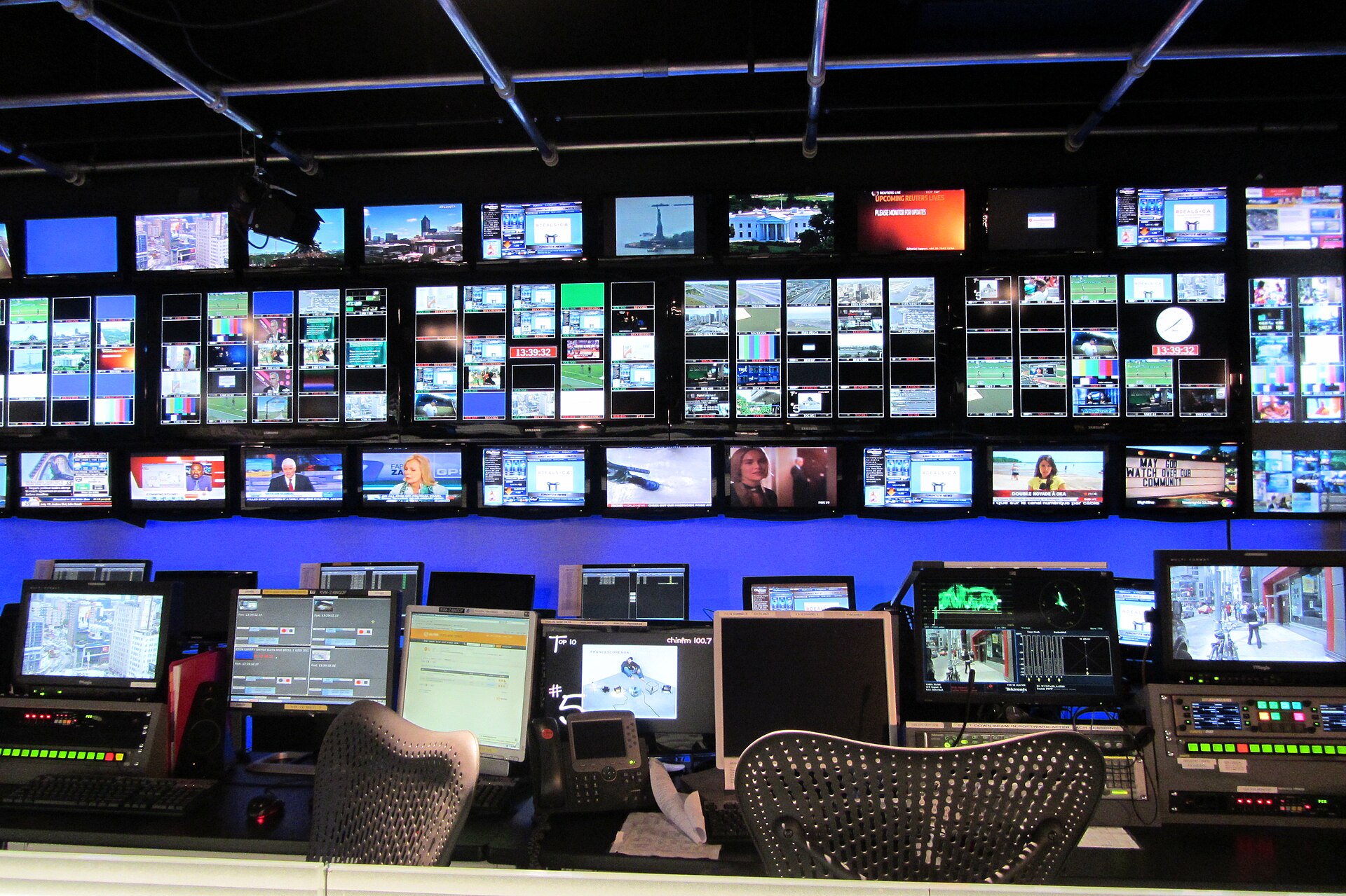 A television broadcast control room with banks of monitors